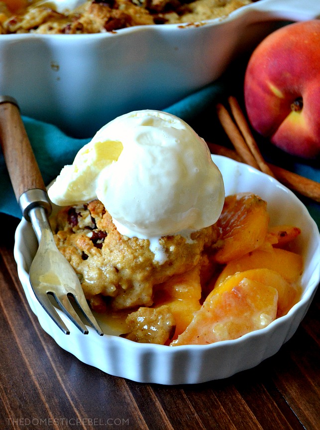 Oatmeal peach cobbler in a small, white ramekin topped with ice cream