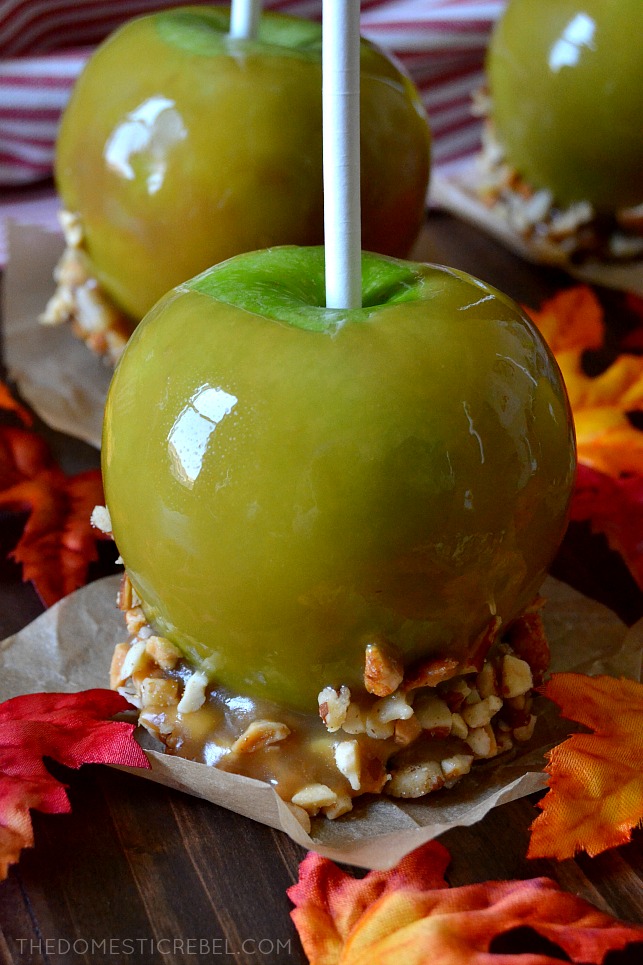 One, green caramel apple with peanuts on parchment paper