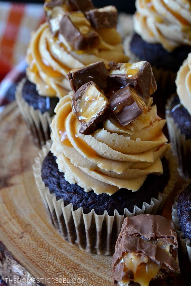 These Super Easy Snickers Cupcakes are heavenly, delicious and simple! They start with a moist and fudgy chocolate cupcake that's topped with a silky, creamy peanut butter frosting and is topped with chopped chewy Snickers pieces and lots of salted caramel sauce! Perfect for using up leftover candy! 