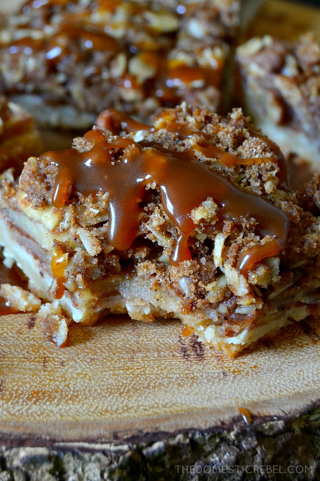 A bite taken out of a dutch apple pie bar topped with caramel