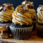 These Super Easy Snickers Cupcakes are heavenly, delicious and simple! They start with a moist and fudgy chocolate cupcake that's topped with a silky, creamy peanut butter frosting and is topped with chopped chewy Snickers pieces and lots of salted caramel sauce! Perfect for using up leftover candy!