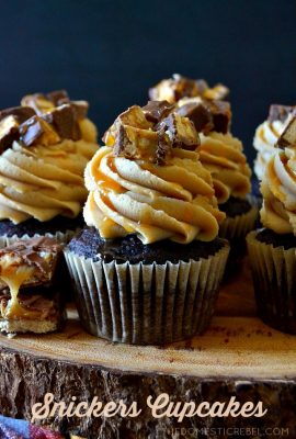 These Super Easy Snickers Cupcakes are heavenly, delicious and simple! They start with a moist and fudgy chocolate cupcake that's topped with a silky, creamy peanut butter frosting and is topped with chopped chewy Snickers pieces and lots of salted caramel sauce! Perfect for using up leftover candy!