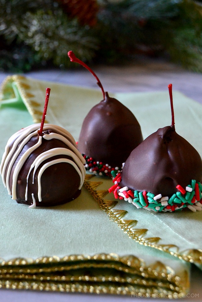 Three Oreo truffle cherries with red and green sprinkles, one with white chocolate drizzle
