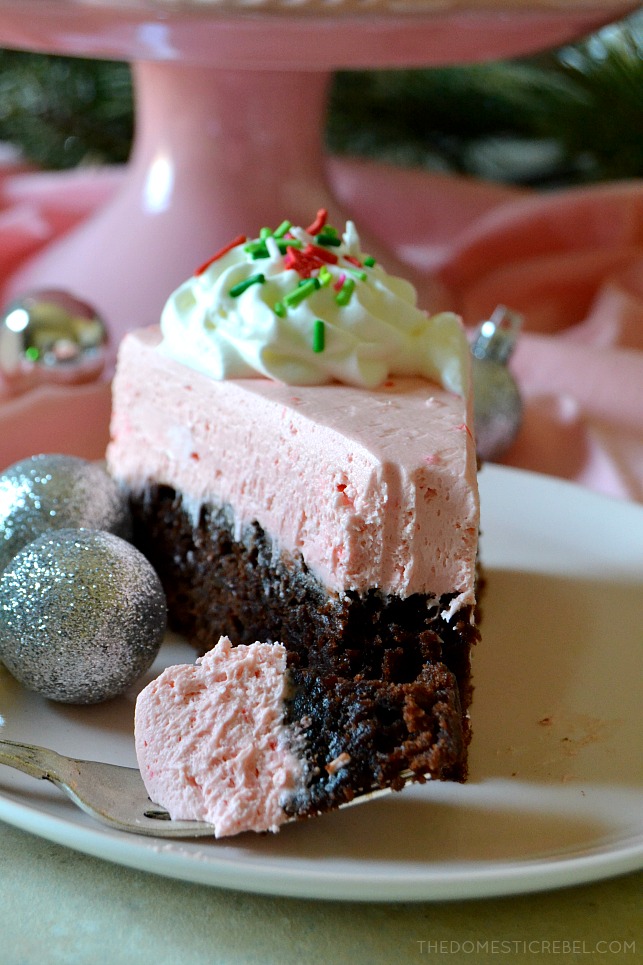 A bite of peppermint brownie cheesecake on a fork in front of a slice