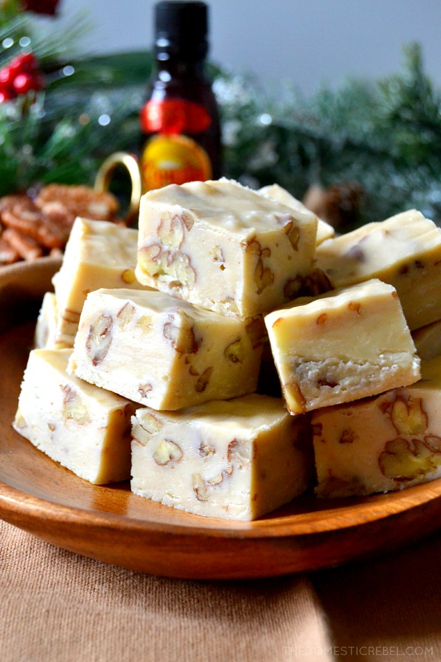 Pile of pieces of Kahlua fudge on a wooden plate with a holiday-themed backdrop