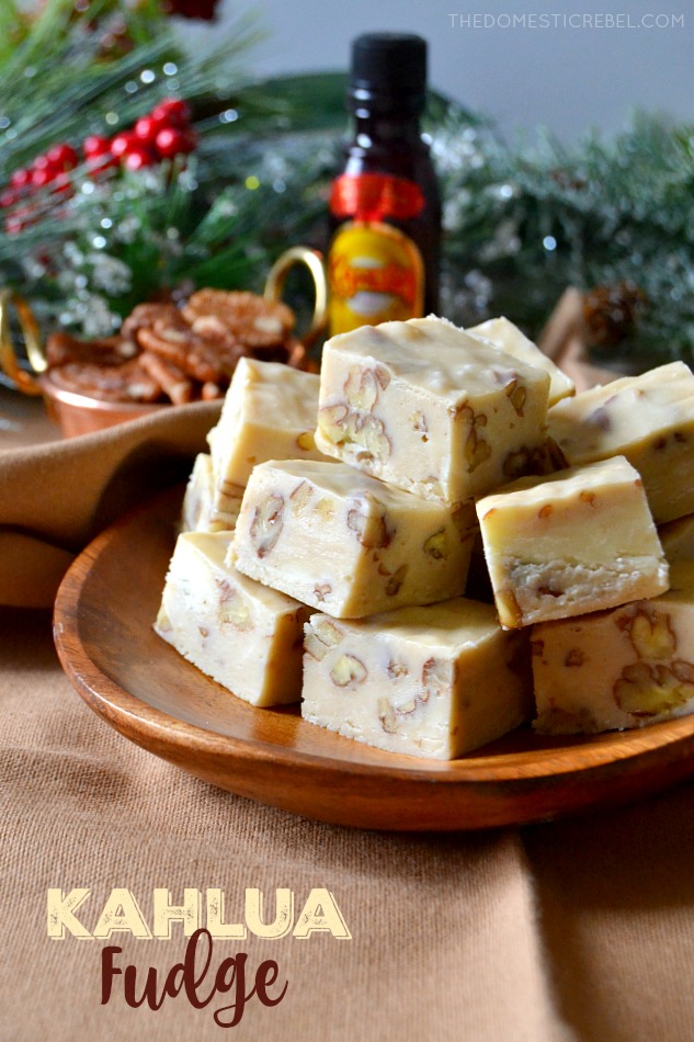 Stack of Kahlua fudge pieces sitting on a wooden plate in front of a holiday backdrop