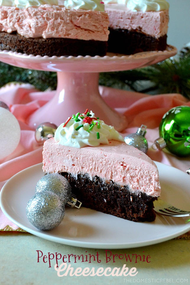 Slice of peppermint brownie cheesecake on a plate next to two sparkly silver ornaments