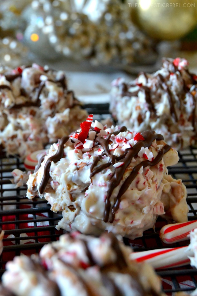 Close-up of a white chocolate peppermint bark pretzel candy on wire rack in front of more pieces of candy