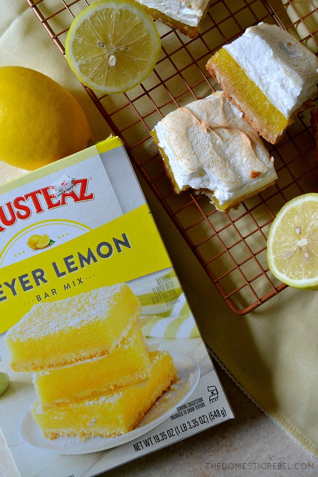 An overhead shot of two lemon meringue pie bars, lemons, and a box of Krusteaz Meyer Lemon Bar Mix