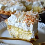 This is the BEST recipe for Homemade Coconut Cream Pie! Silky, decadent, creamy coconut custard in a flaky, buttery pie crust and topped with fresh sweetened whipped cream and toasted nutty coconut. So easy, delectable and makes for an amazing party dessert!