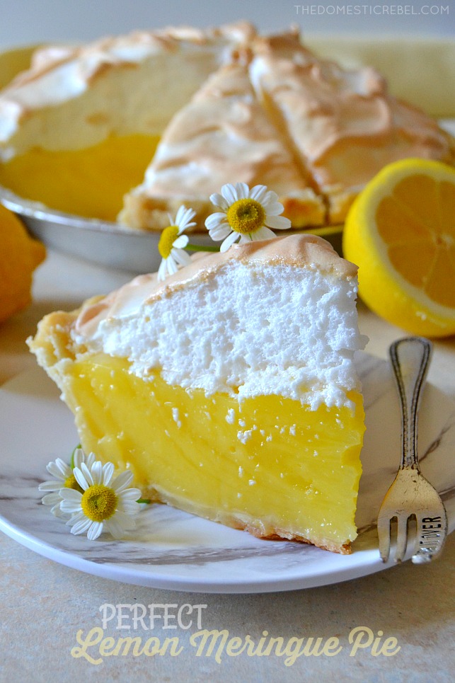 perfect lemon meringue pie slice with small flowers on white plate with fork