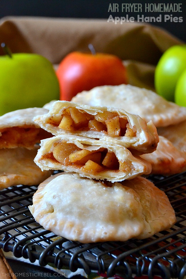 apple hand pies arranged on black wire rack with apples in background