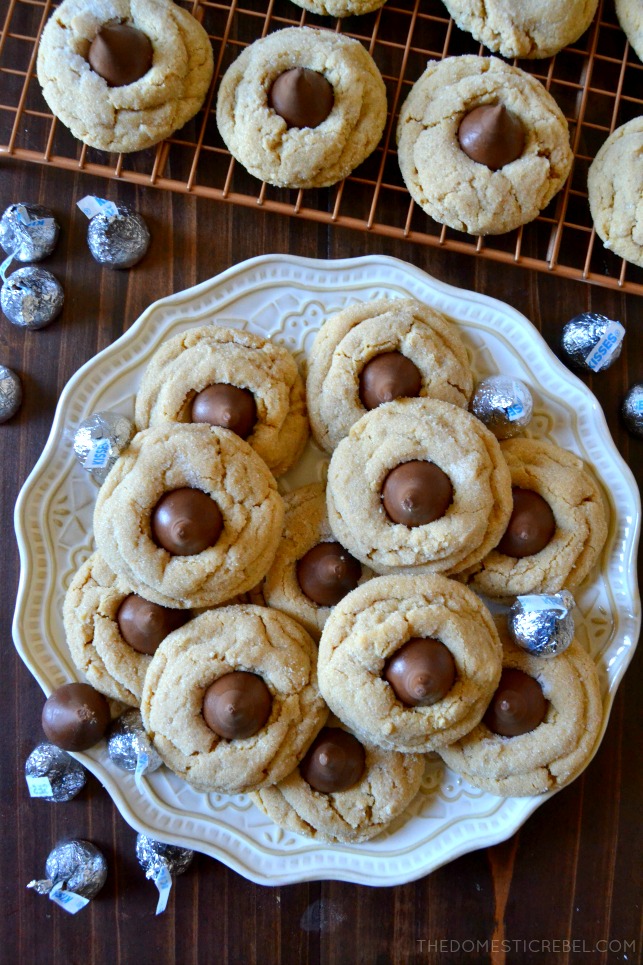peanut butter blossoms arranged in pile on white plate with hershey kisses