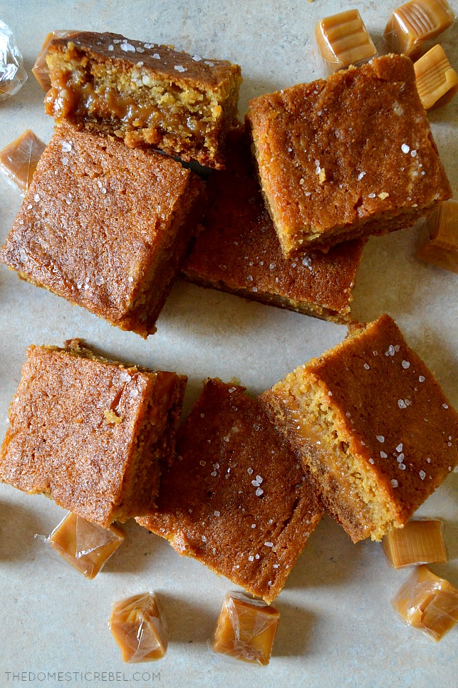 salted caramel blondies arranged in a pile with caramel candies