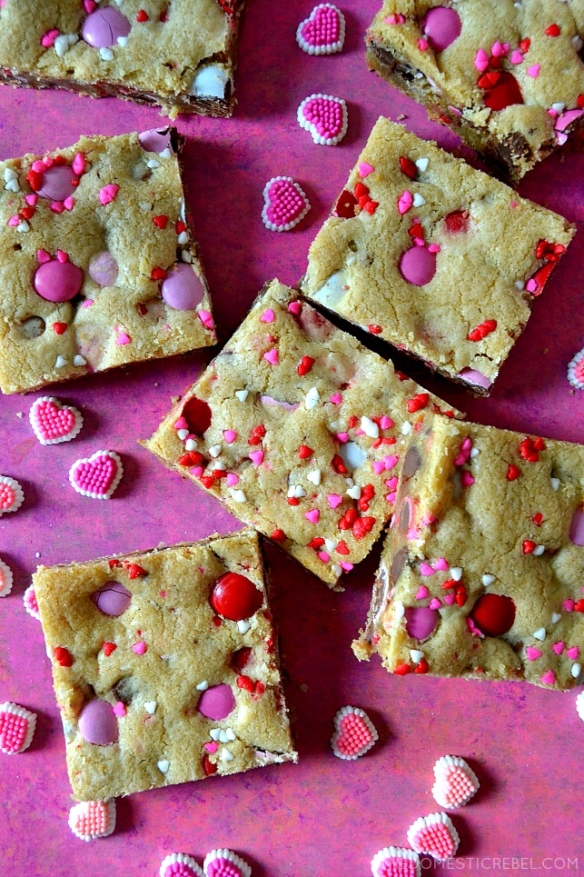 valentine m&m cookie bars arranged on pink wood