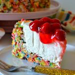 no bake fruity pebbles cheesecake on purple plate with gold fork