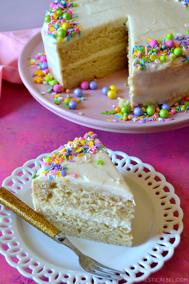 vanilla cake slice on white plate with cake in background