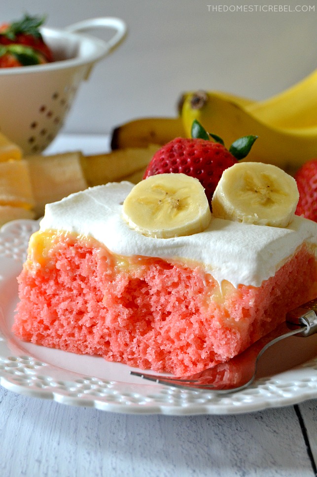 strawberry banana poke cake on white plate with fork