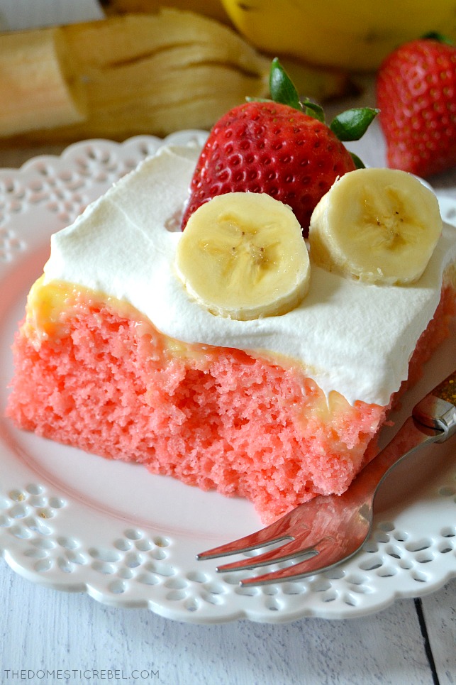closeup of strawberry banana poke cake on white plate with fork