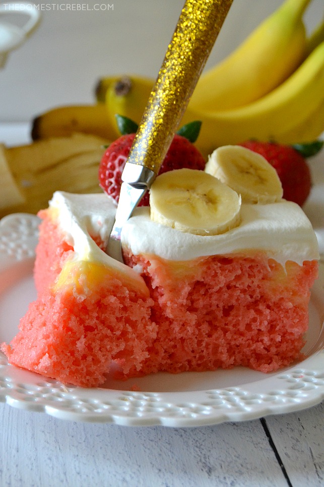 strawberry banana poke cake with fork in it on white plate