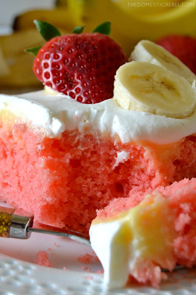 closeup of a strawberry banana poke cake slice with bite missing