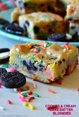 Cookie and cream cake batter blondie on white wood with oreos and sprinkels
