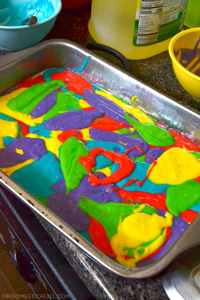 Rainbow Poke Cake batter swirled in metal pan