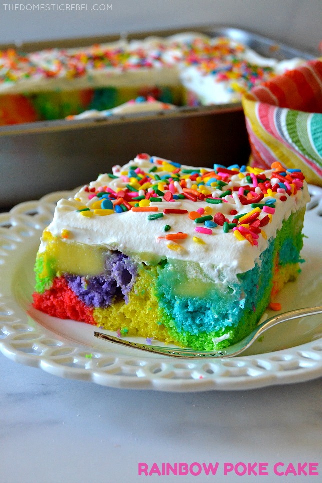 Rainbow Poke Cake on white plate with fabric and pan in background