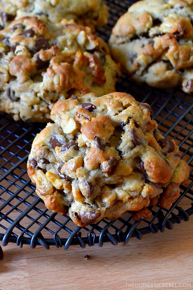 photo of a large choc chip walnut cookie on black wire rack