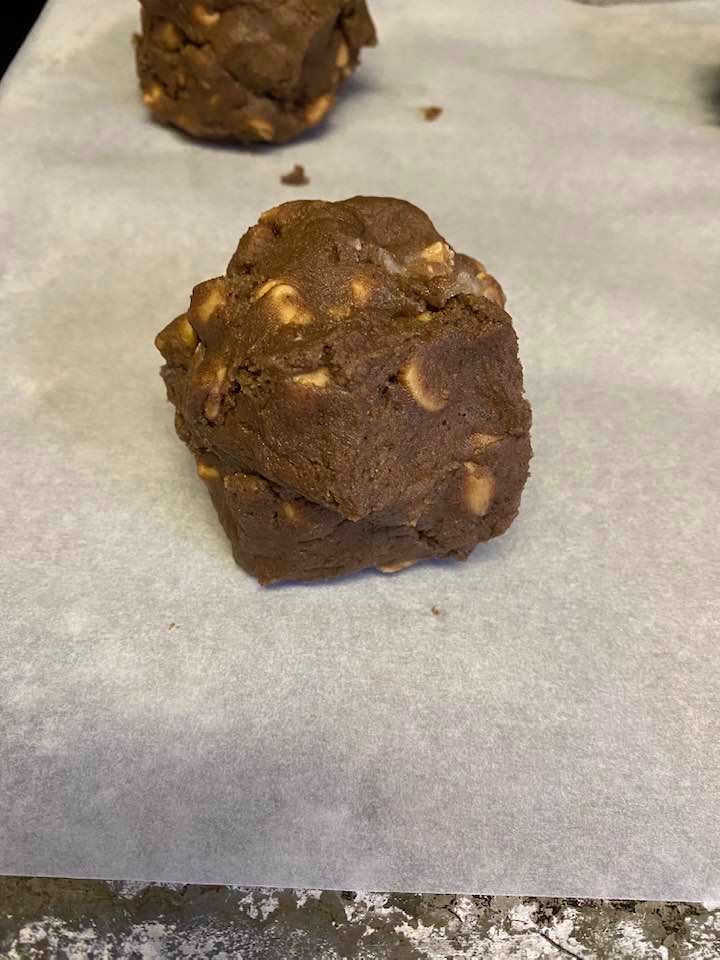 photo of a chocolate PB cookie dough ball on a baking sheet