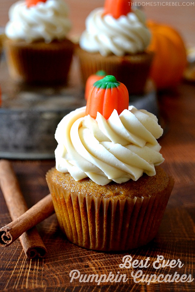 Closeup of pumpkin cupcake with cinnamon sticks on a wood board