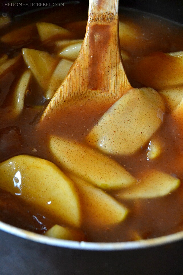 Closeup of apple pie filling in a pot with a wooden spoon