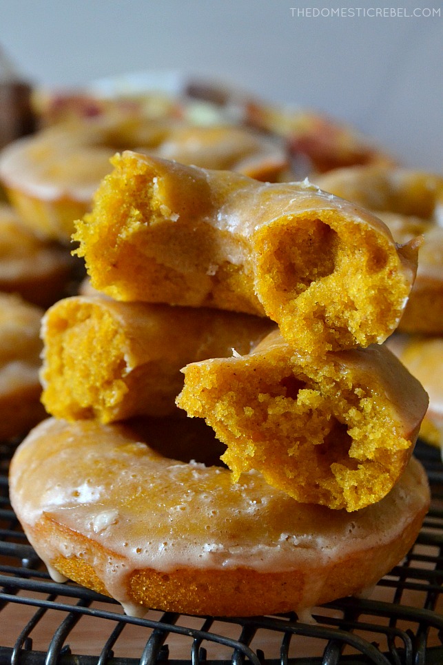 photo of pumpkin cake donuts stacked and split open on wire rack