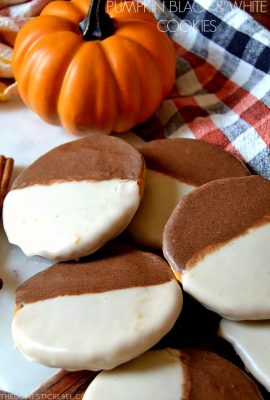 small pile of pumpkin black and white cookies with a pumpkin in the background