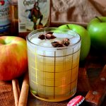 Spiced Rum Apple Cider Cocktail with apples and cinnamon sticks