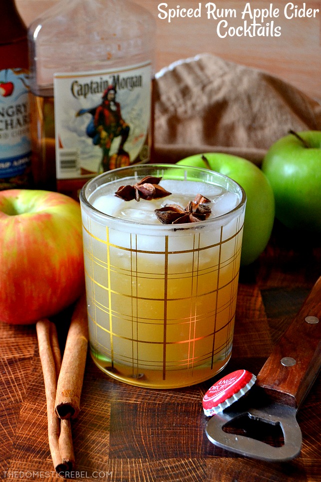 Spiced Rum Apple Cider Cocktail on a wooden board with rum and apples in the background