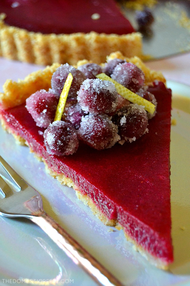 Closeup slice of cranberry lemon tart with a fork on a plate