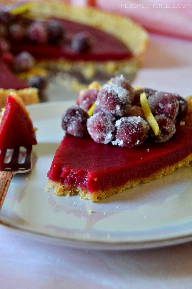 A slice of cranberry lemon tart with a bite missing