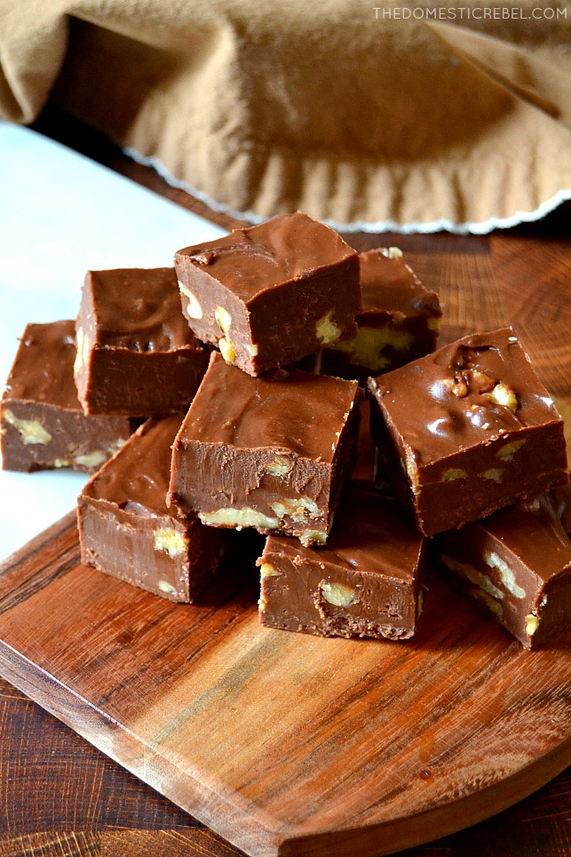 Pile of chocolate walnut fudge pieces on wooden cutting board