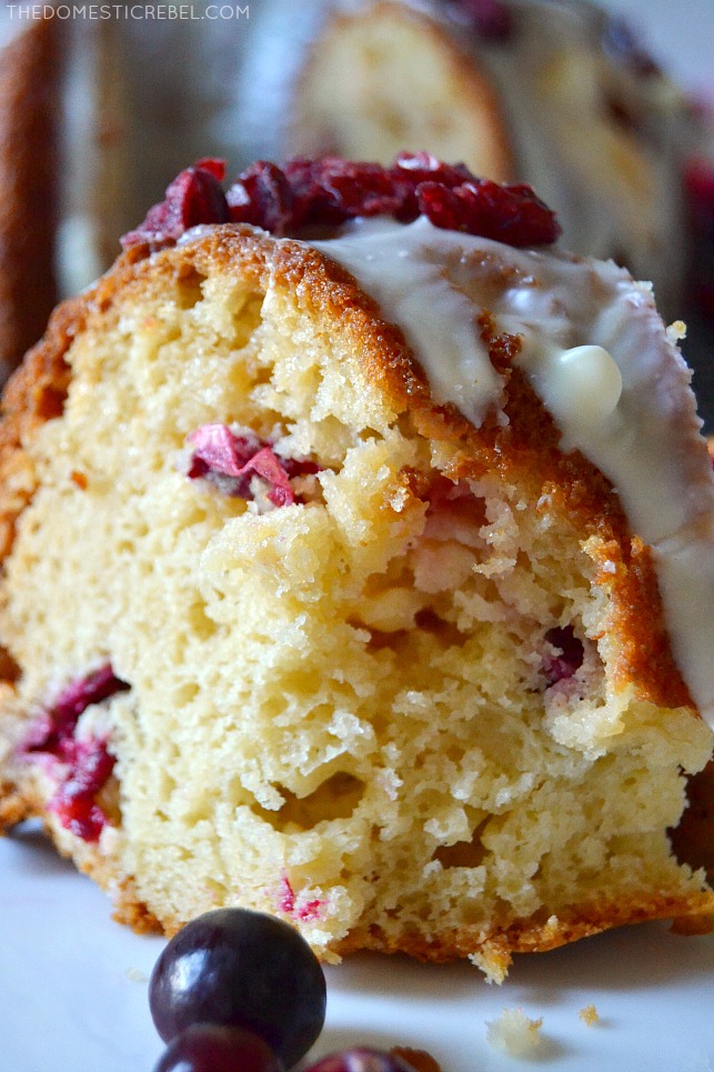 Closeup of a slice of white chocolate cranberry cake with bite missing