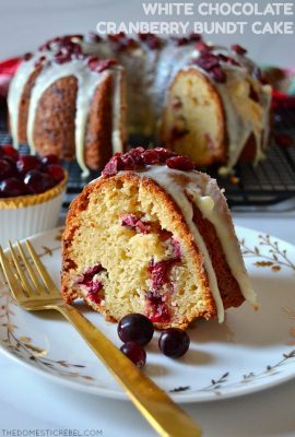 white chocolate cranberry bundt cake slice on white plate with gold fork