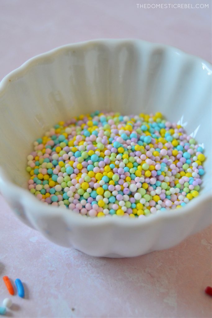 bowl of non-pareils sprinkles on pink background