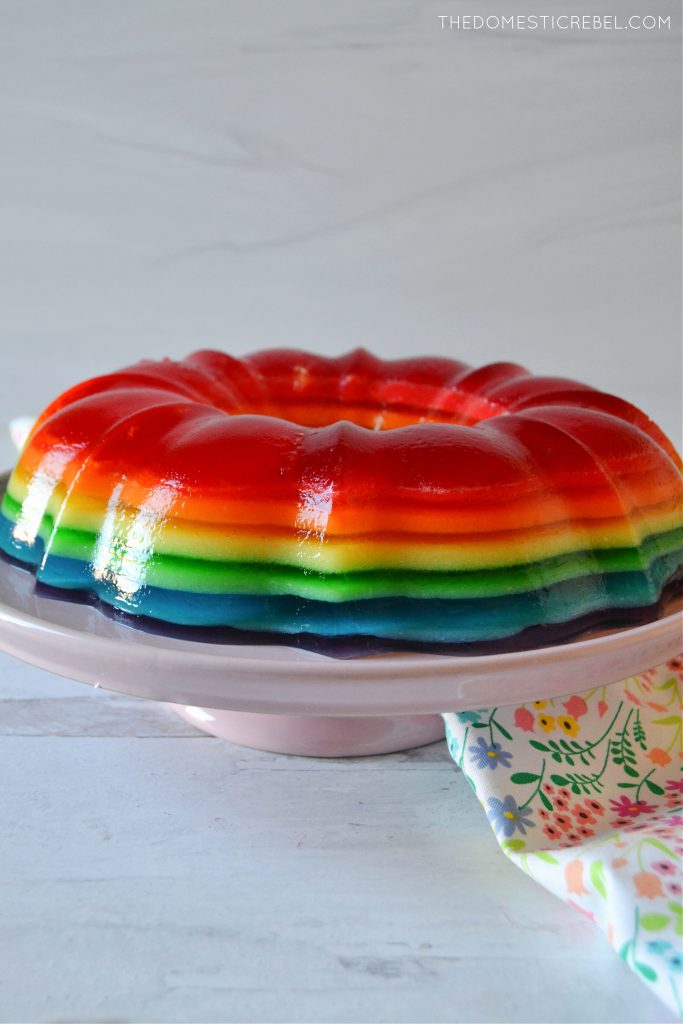 The rainbow jello mold ring on a pink cake stand