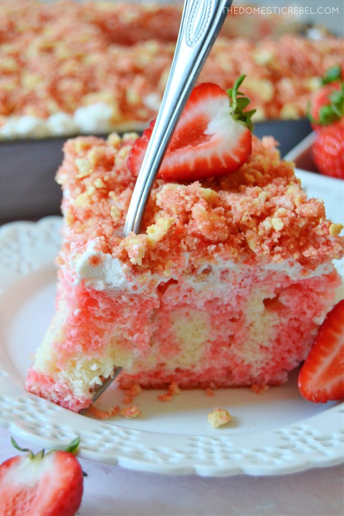 a slice of strawberry crunch poke cake with a fork through it 