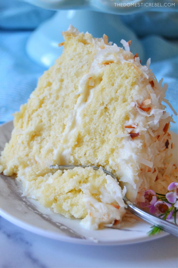 coconut layer cake slice with a fork in it 