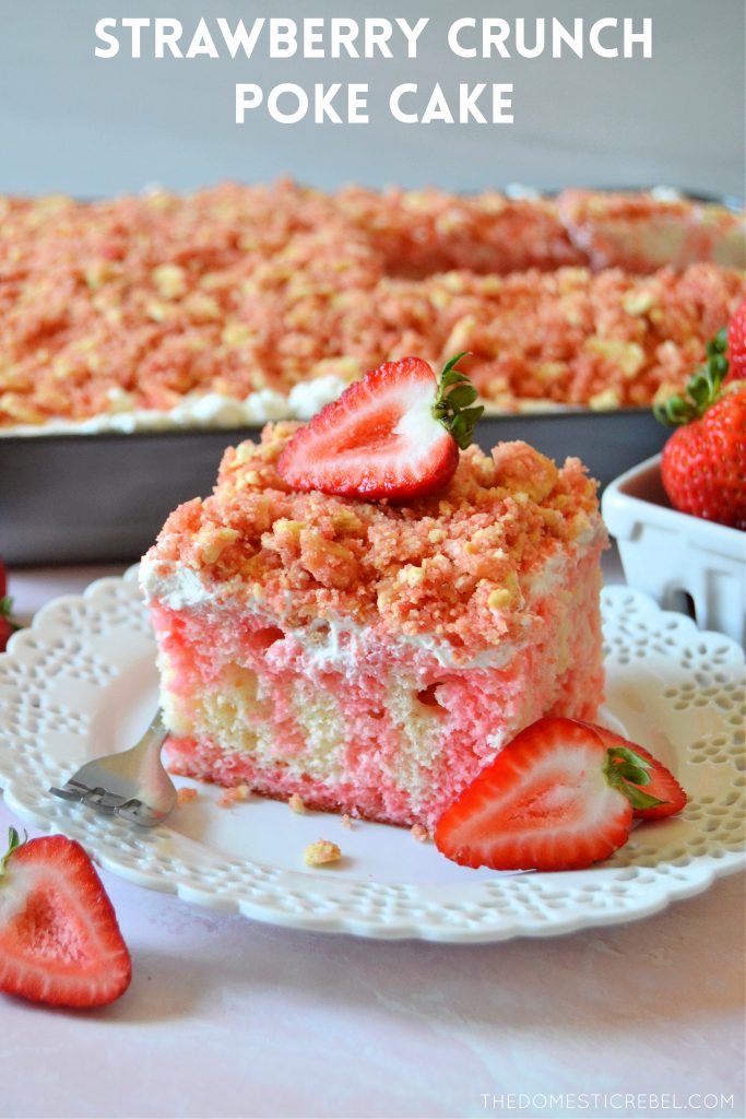 strawberry crunch poke cake slice on a white plate with fresh strawberries