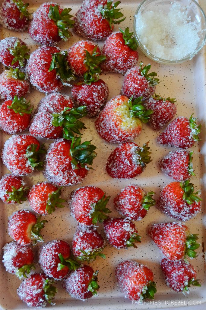 a pink metal tray with drunken rosé strawberries on it