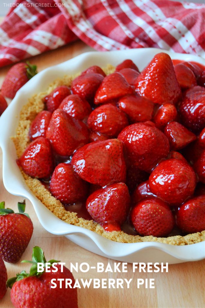 a glossy strawberry pie in a white ruffled dish with strawberries around it 