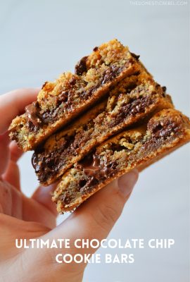 author holding a stack of three gooey chocolate chip cookie bars