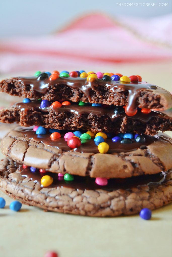 closeup of a stack of cosmic brownie cookies, one is broken open to show the texture